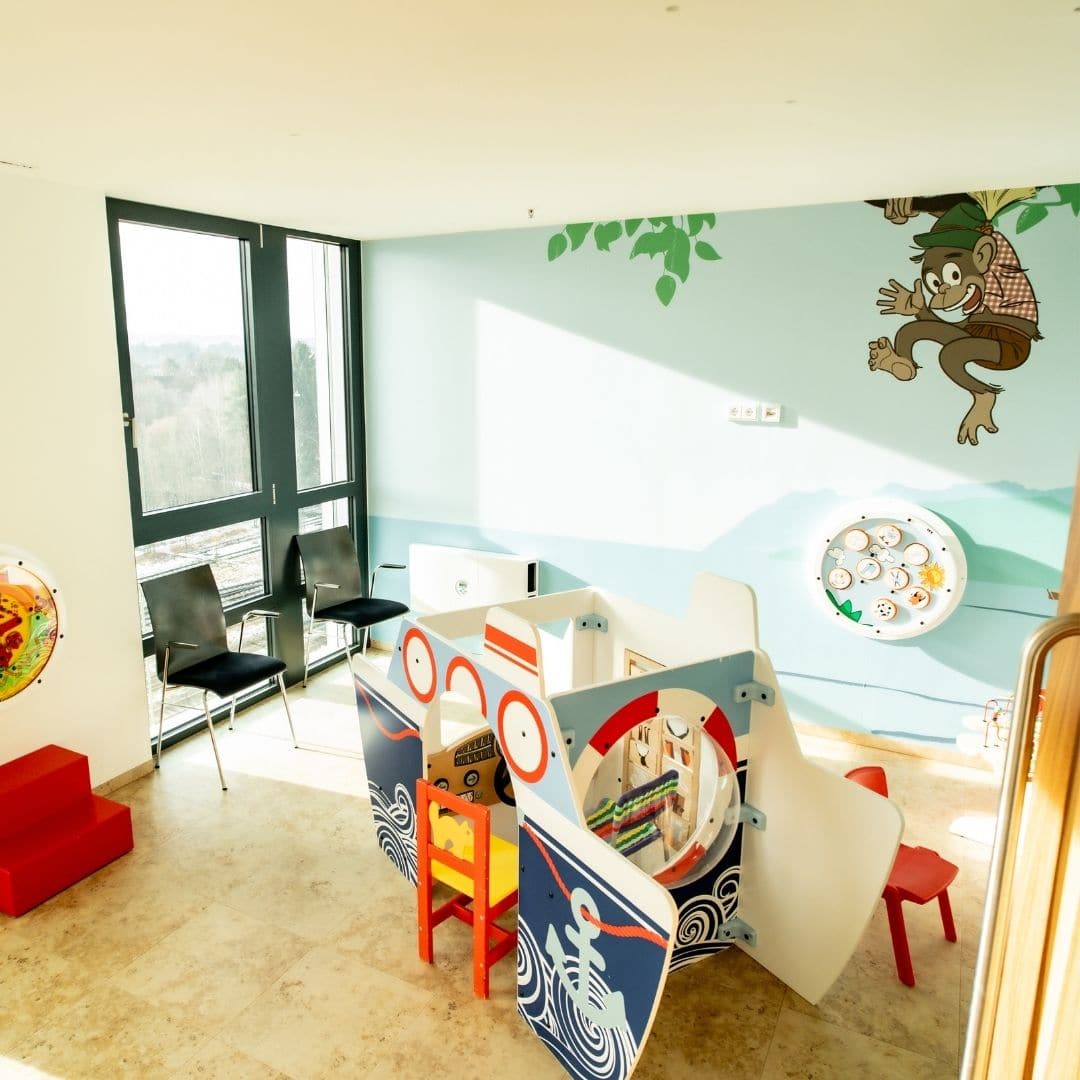 Kinderwartezimmer mit Spielbereich und bunten Wandmotiven